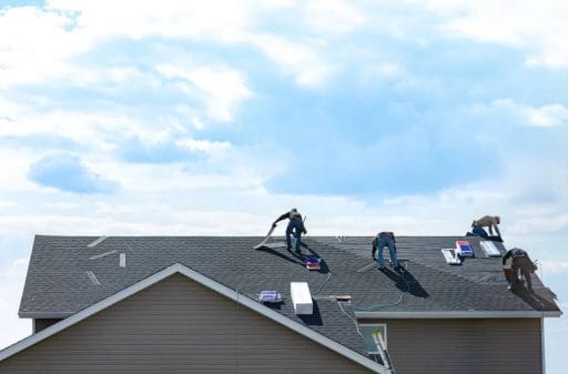 4 construction workers fixing roof installation
