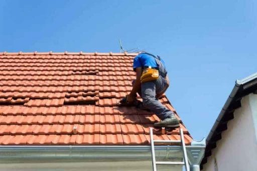 Worker on clay tile roof causing damage is a roof scam
