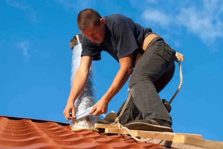 man installing vent on tile roof; tile roof cost