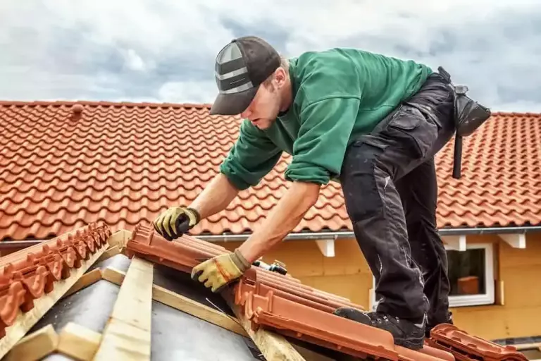 man installing tile roof on house; tile roof cost