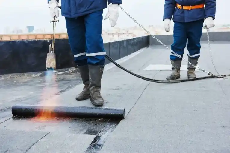 Flat roof installation with roofing felt and flame torch