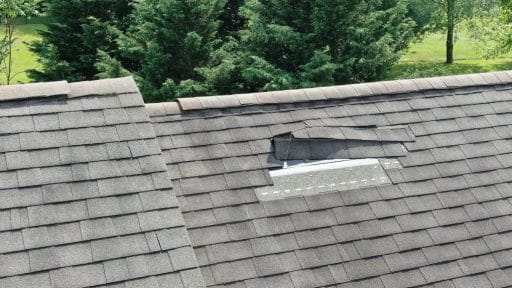 aerial view of roof with missing shingles; should I repair or replace my roof